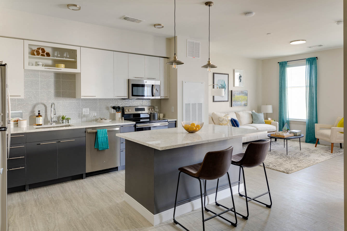 a kitchen and living room with an island and chairs